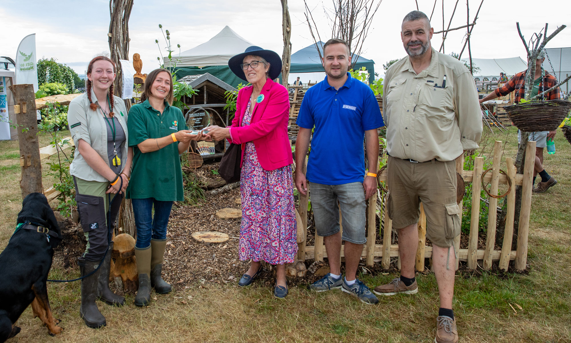 team of gardeners receiving award in front of their show garden