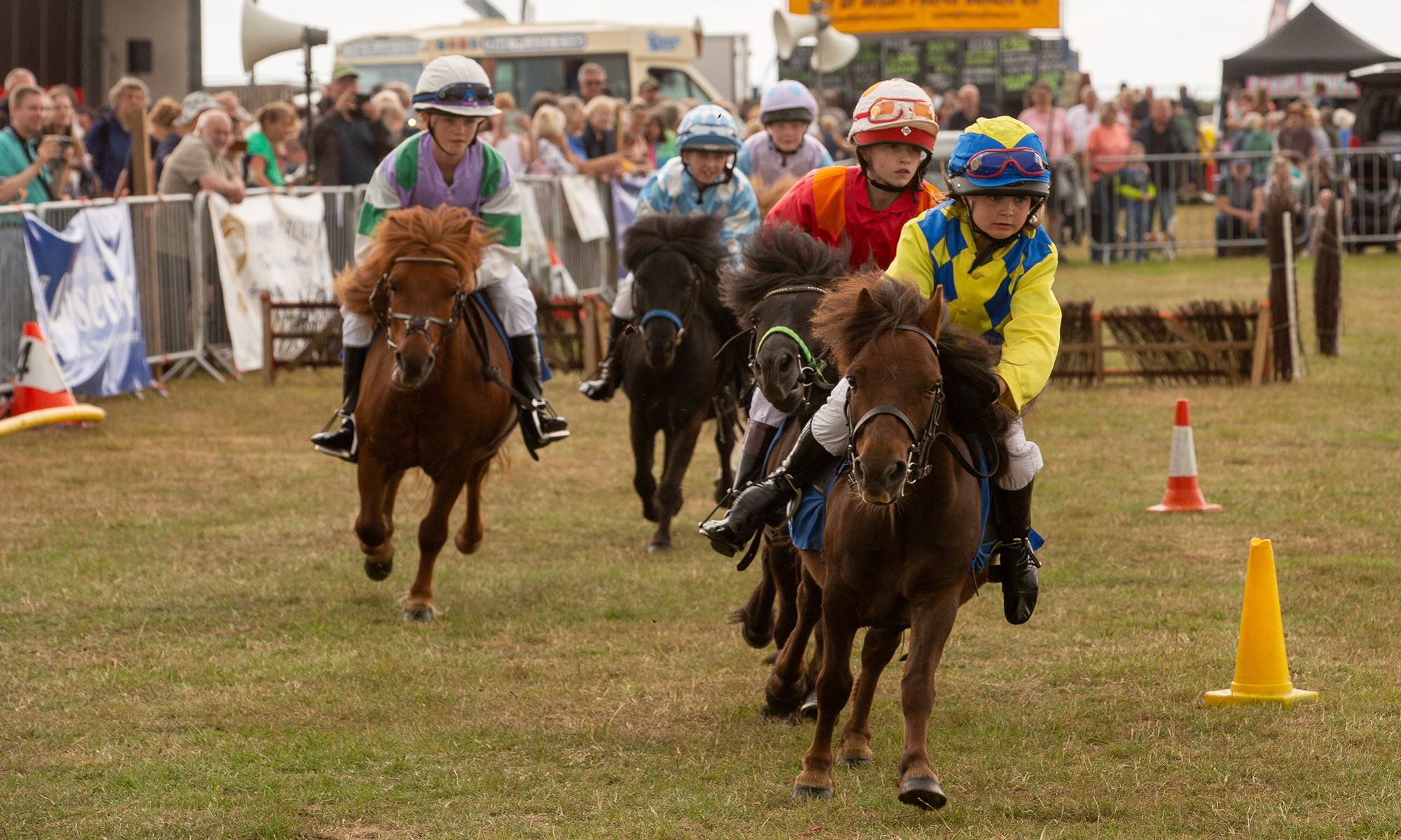riders rqcing shetland ponies on a course